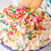 Close up square image of Funfetti Cake Batter Dip in bowl with cookies and sprinkles.