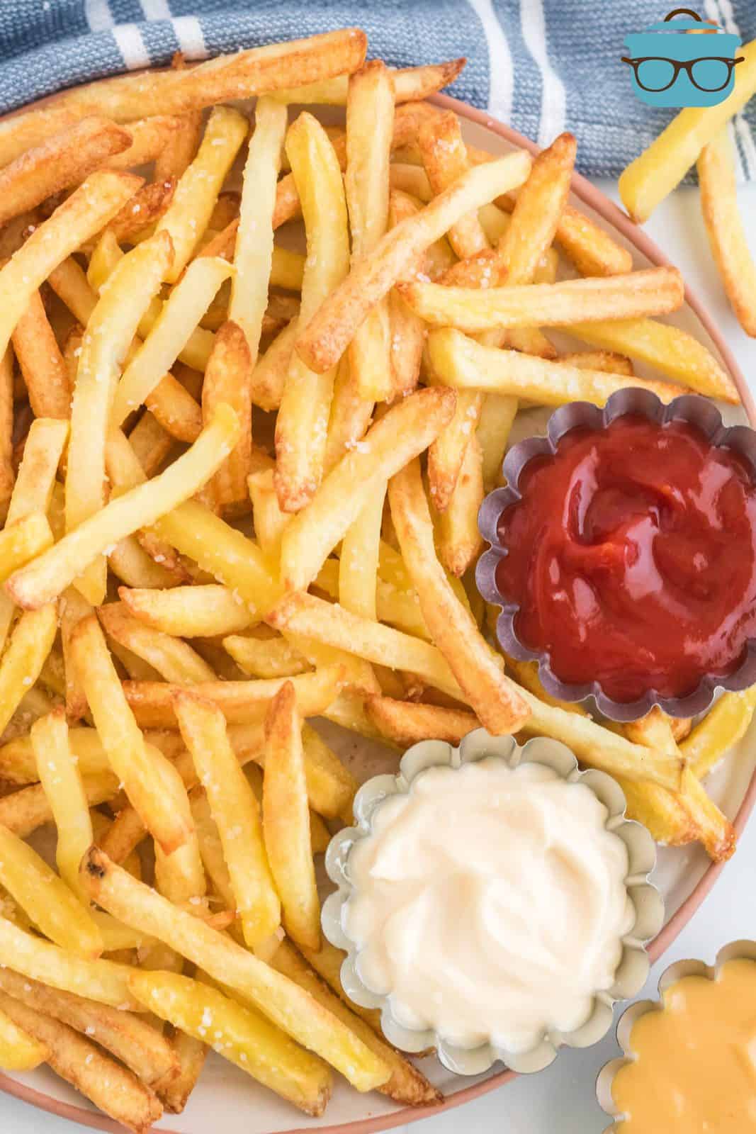 Air Fryer Frozen French Fries on platter with dipping sauces.