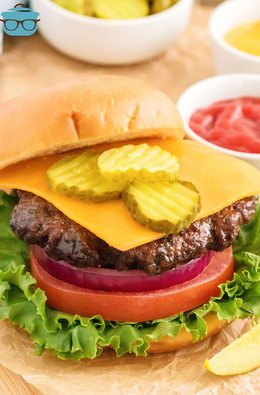 Air Fryer Hamburger on bun with lettuce, tomato, cheese and pickles.
