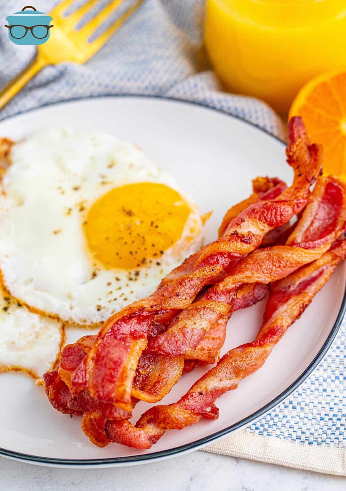 Air Fryer Twisted Bacon on plate with eggs.