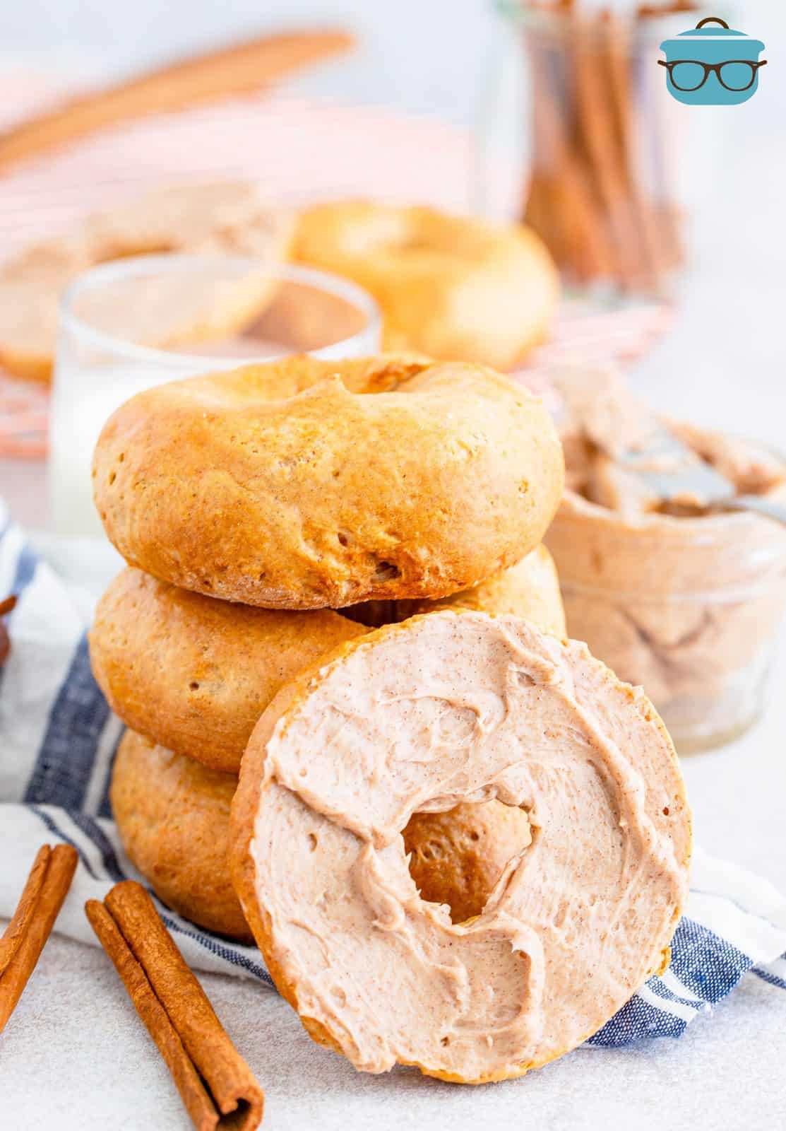 Stacked Air Fryer Cinnamon Bagels with one cut in half and spread with a cinnamon honey butter.