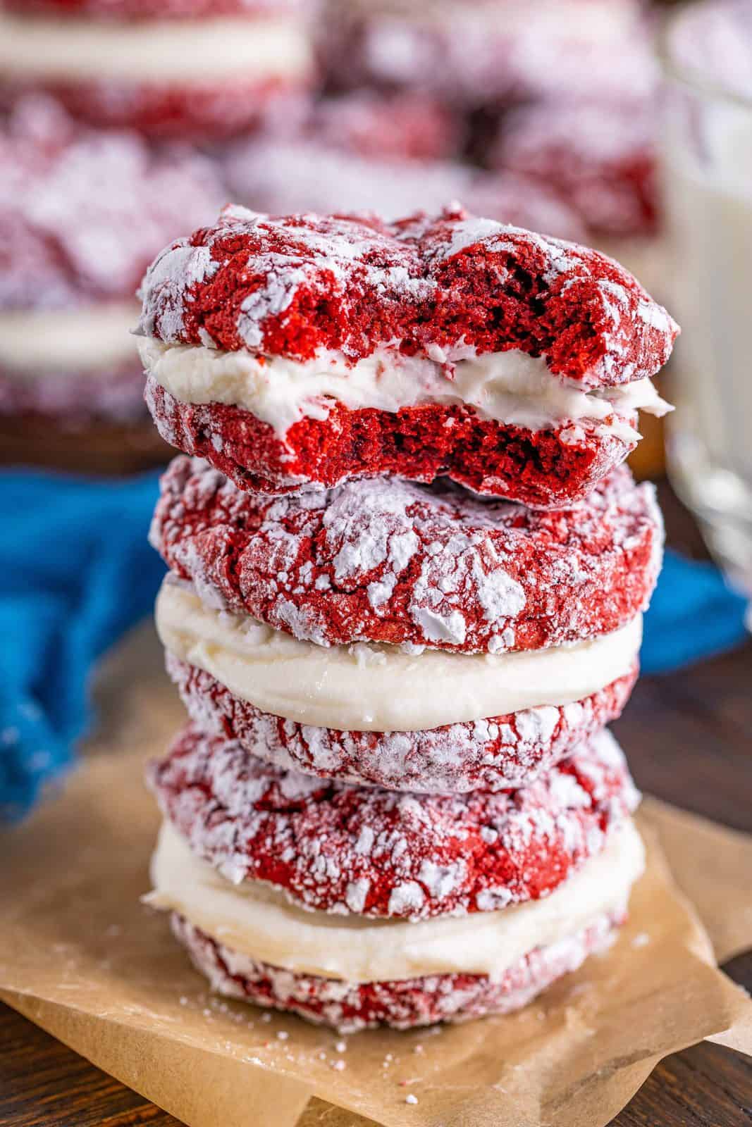 Three stacked Red Velvet Sandwich Cookies with top cookie having a bite taken out of it.