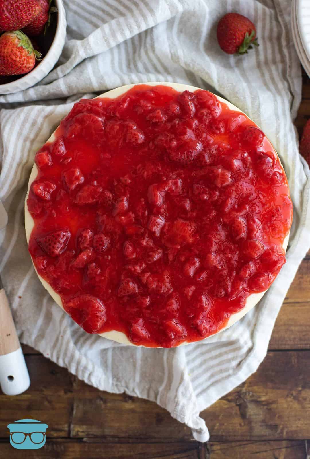 Overhead of New York Cheesecake covered in strawberry sauce.