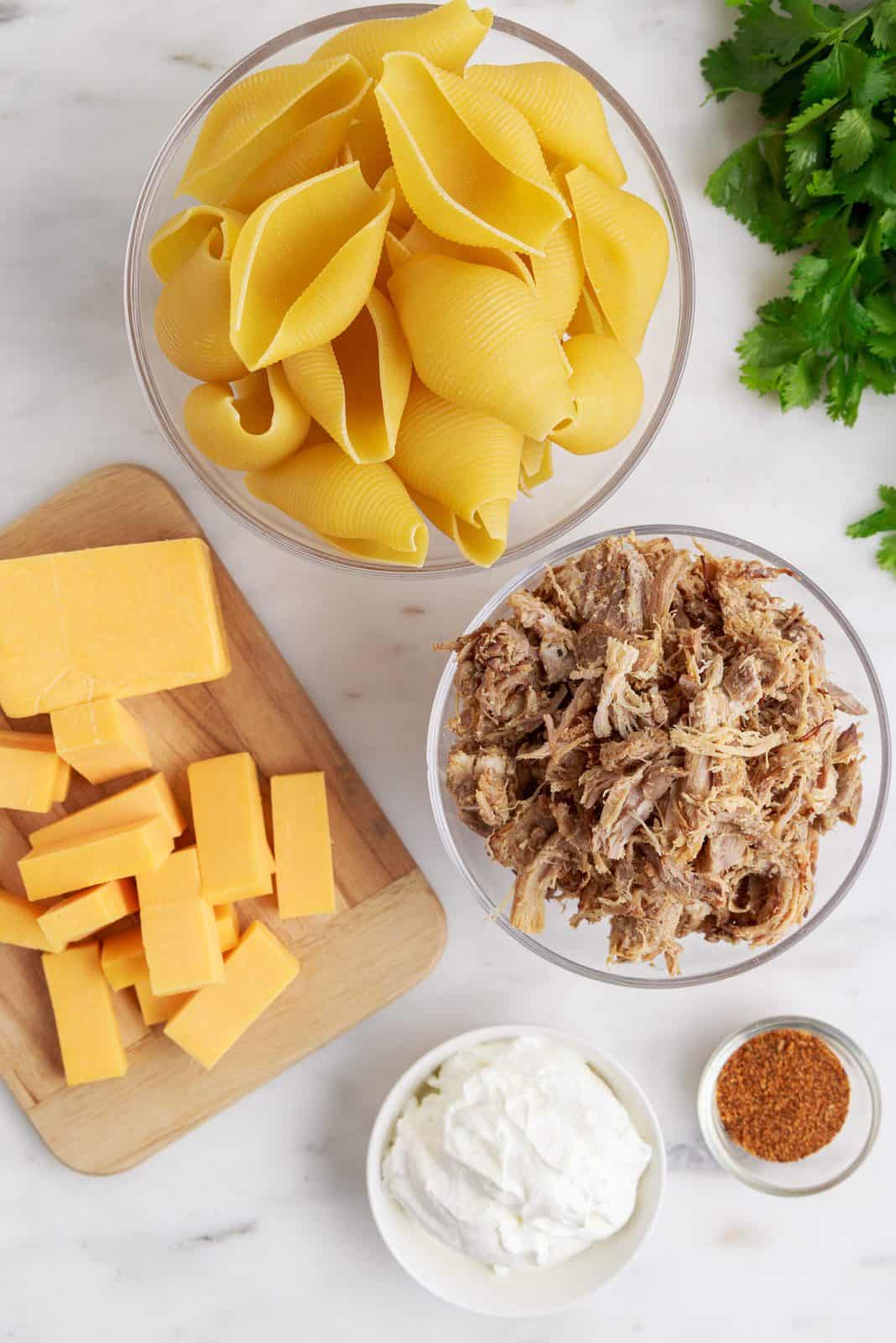 Ingredients needed: jumbo pasta shells, carnitas, cheddar cheese, sour cream and taco seasoning.