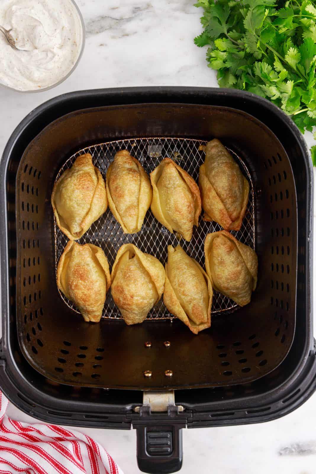 Finished shells in air fryer showing golden brown shells.