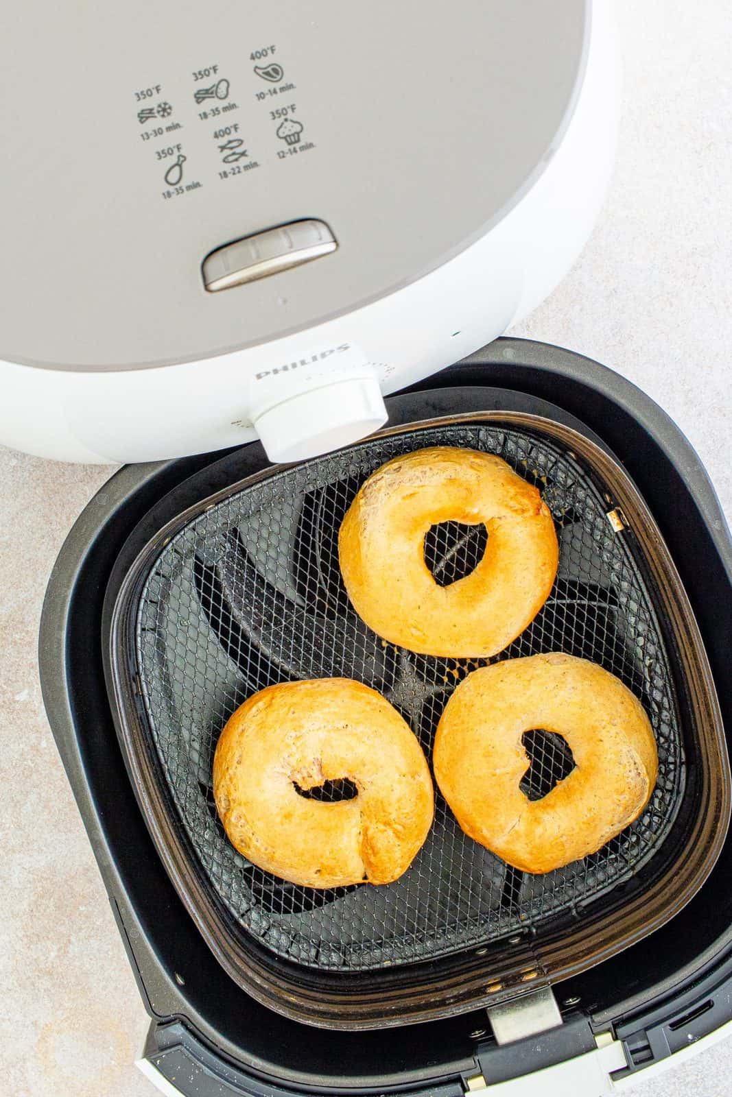 Overhead of finished bagels in air fryer.