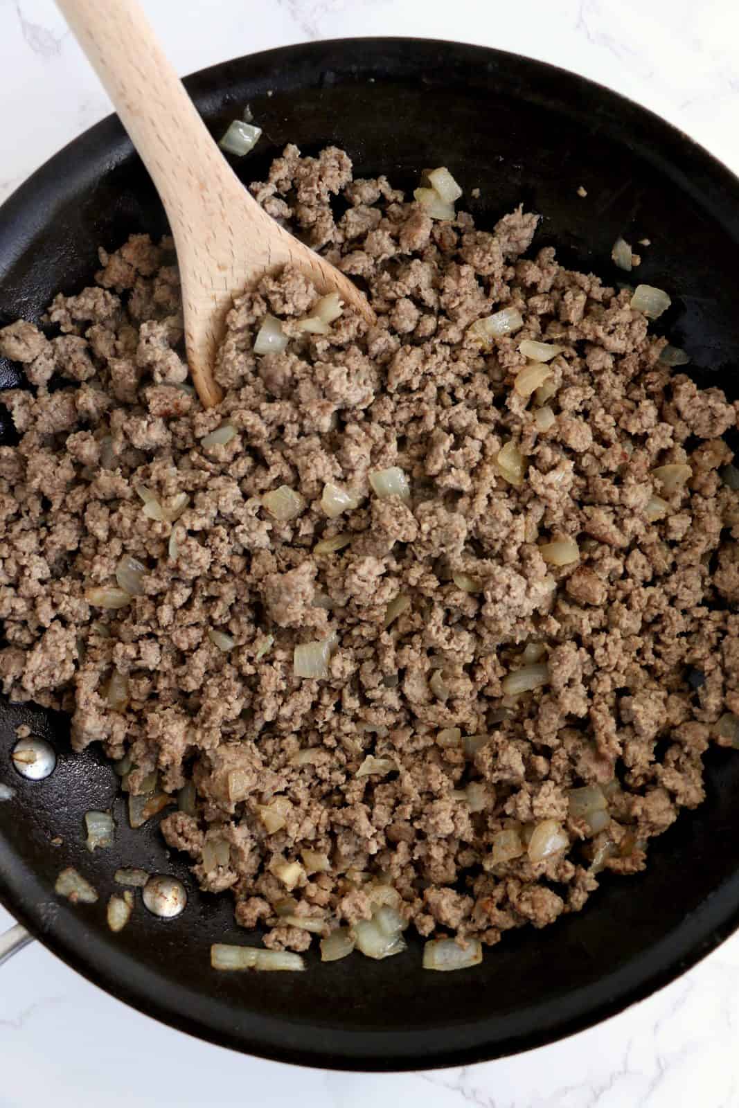 Ground beef and onion cooked in saute pan.