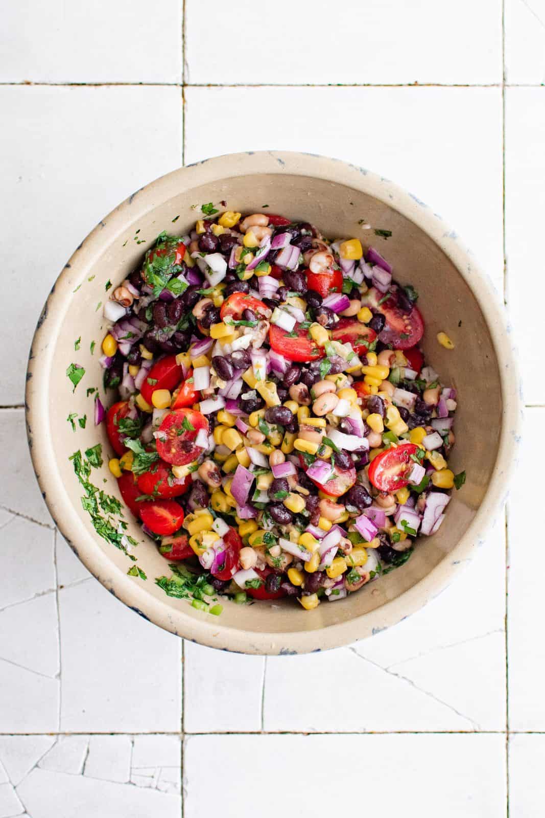Corn, black beans, black eyed peas, tomatoes, cilantro, onion, jalapeno, garlic, olive oil, lime juice and salt in large bowl tossed together.