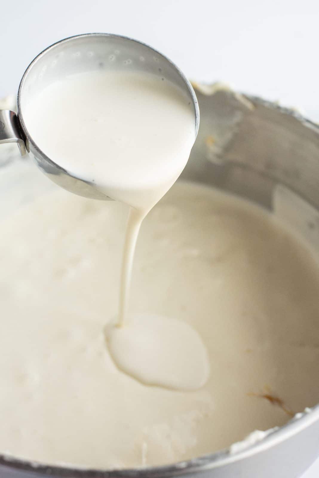 Eggs, egg yolks and heavy cream added to cream cheese mixture.