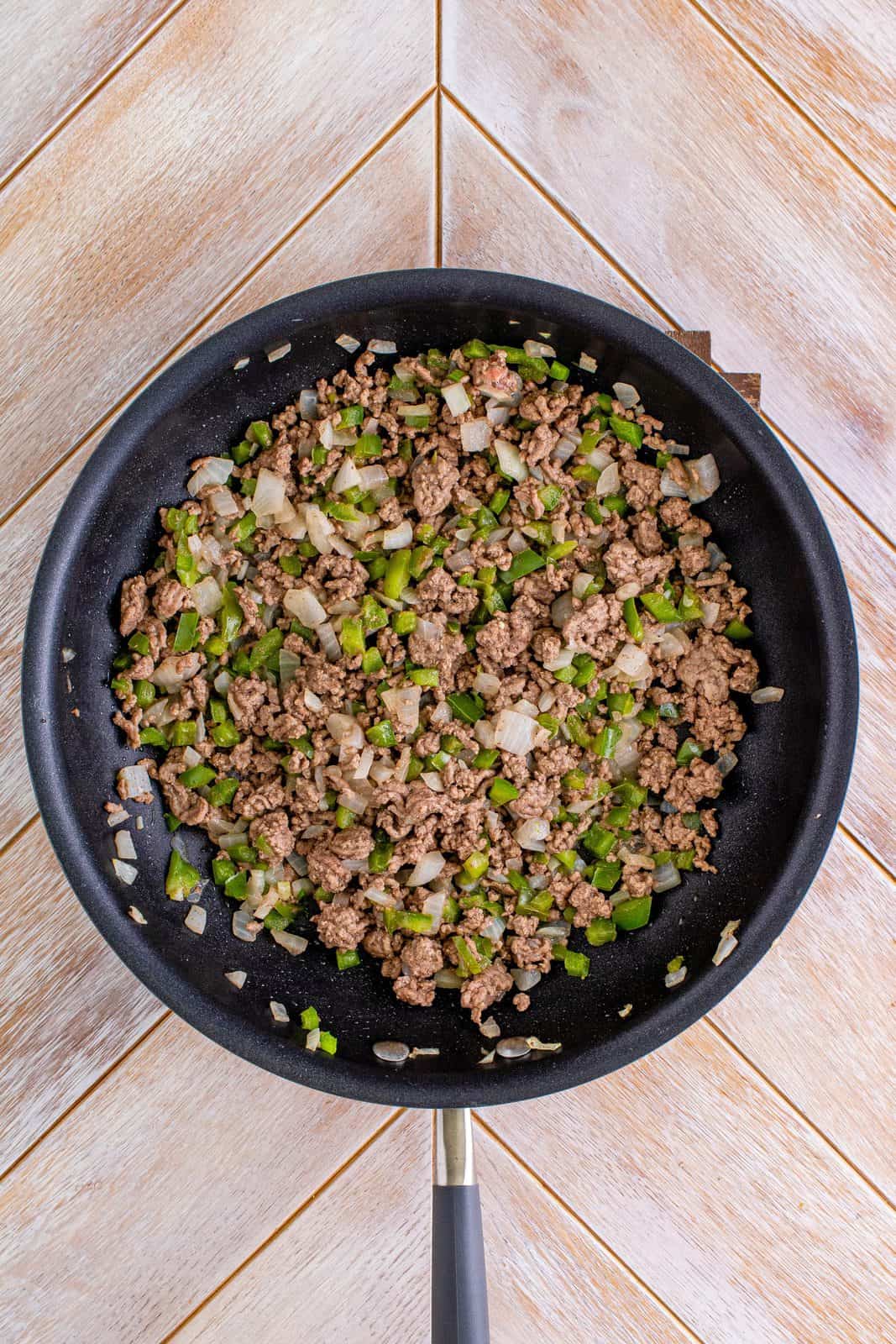 Ground beef, onion and green peppers cooked in saute pan.