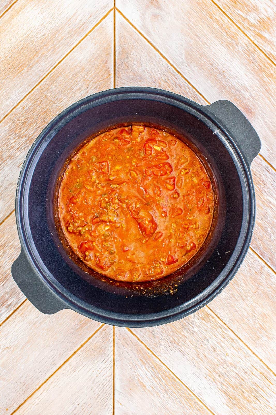 Garlic, pasta sauce, tomato sauce, diced tomatoes, water, Italian seasoning and sugar added to crock pot and stirred.