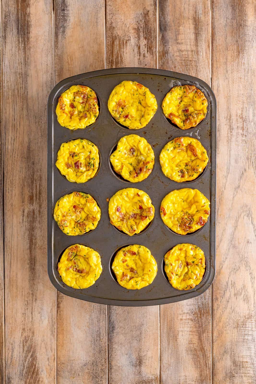 fully baked egg bites shown in a muffin tin. 