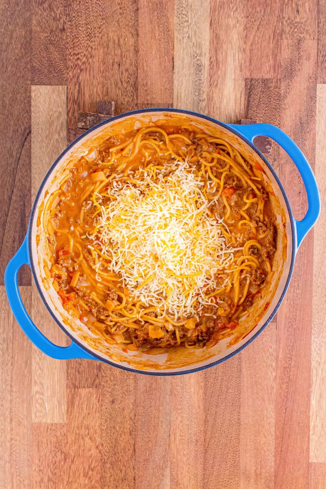 Mexican cheese added to pasta in dutch oven.