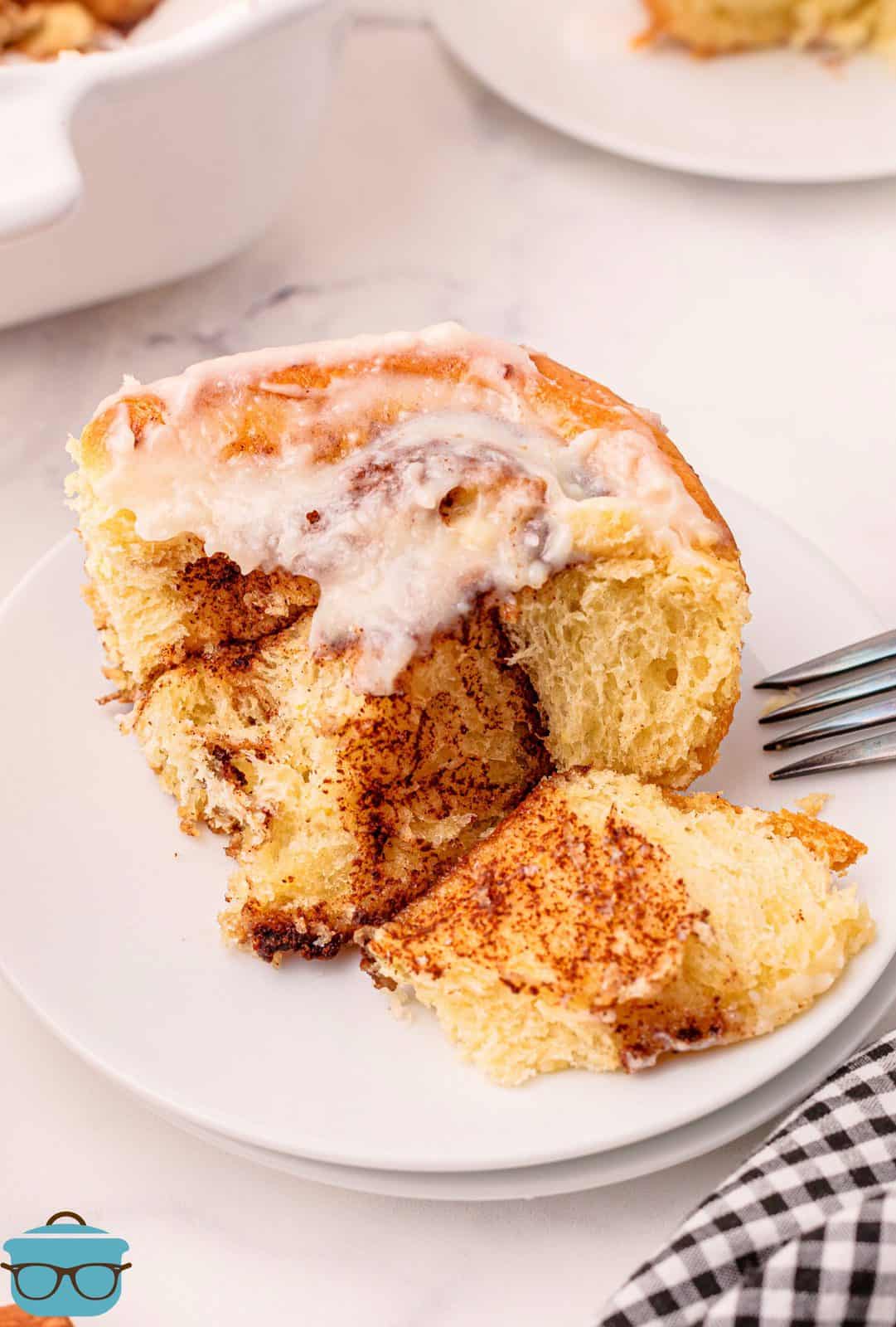 One Homemade Cinnamon Roll on plate cut open showing filling.