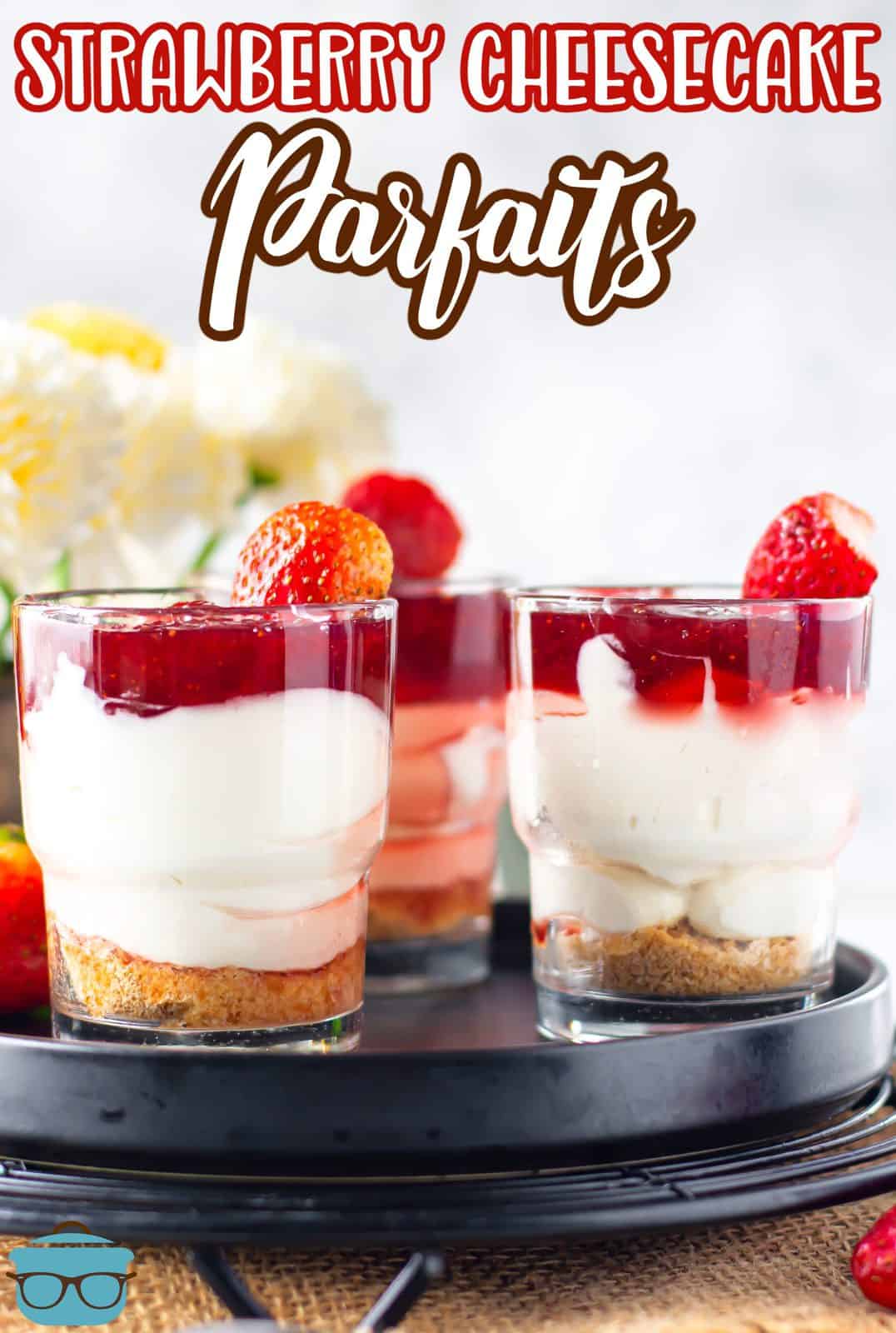 Pinterest image of Strawberry Cheesecake Parfaits showing layers on black tray.