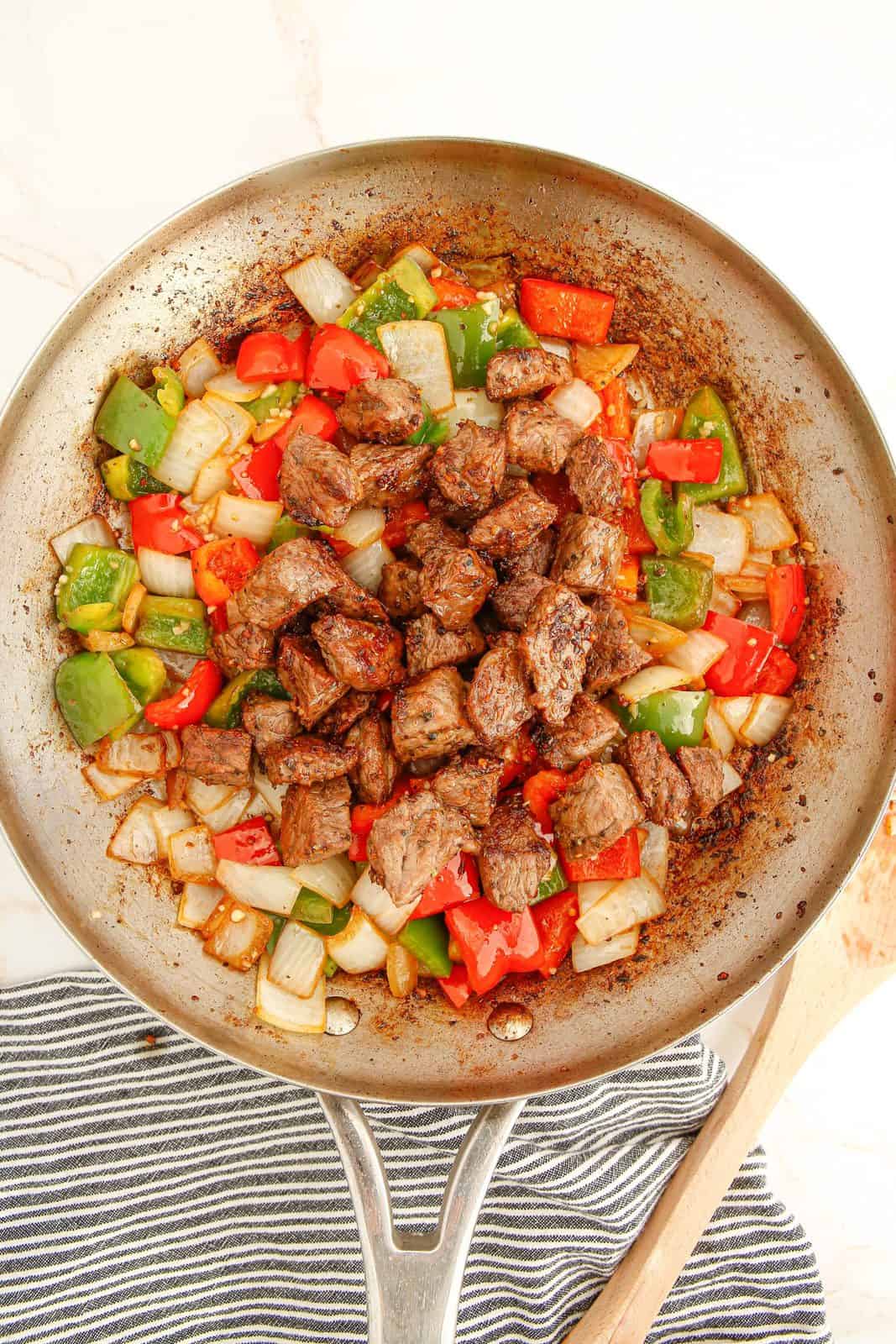 Steak Tips and Peppers in pan being mixed together before serving.