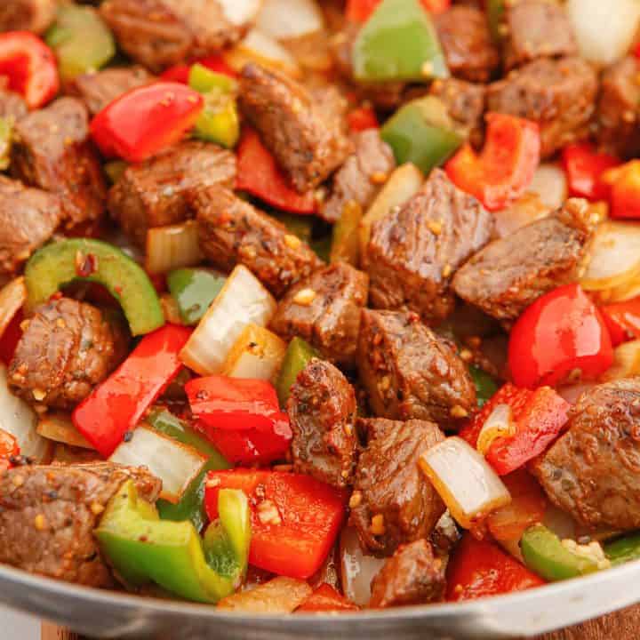 Square close up image of Steak Tips with Peppers in pan.