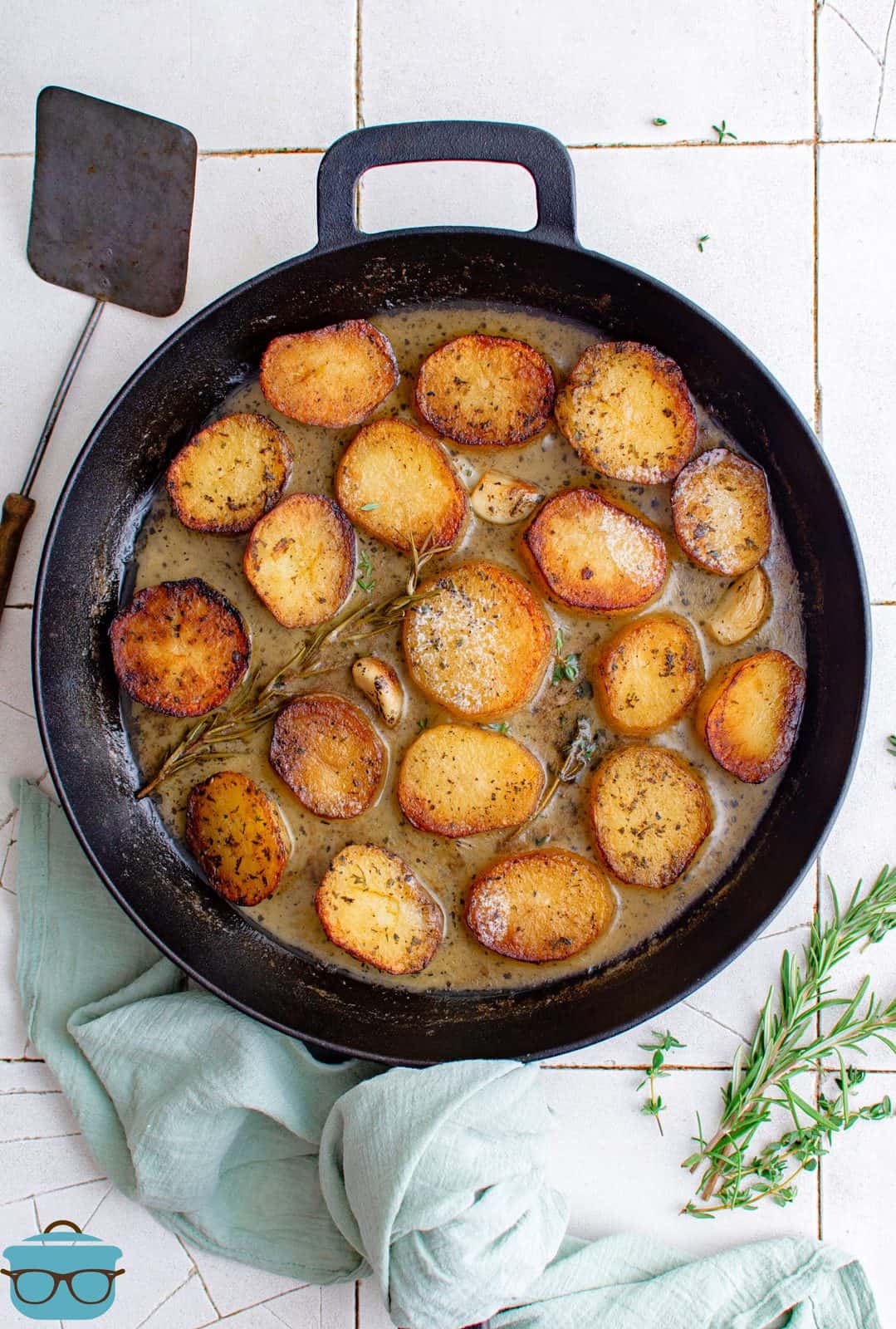 Finished Melting Potatoes in skillet with butter sauce and fresh herbs.
