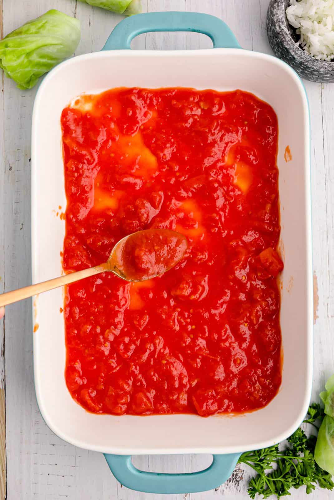 Sauce spread over bottom of baking dish.