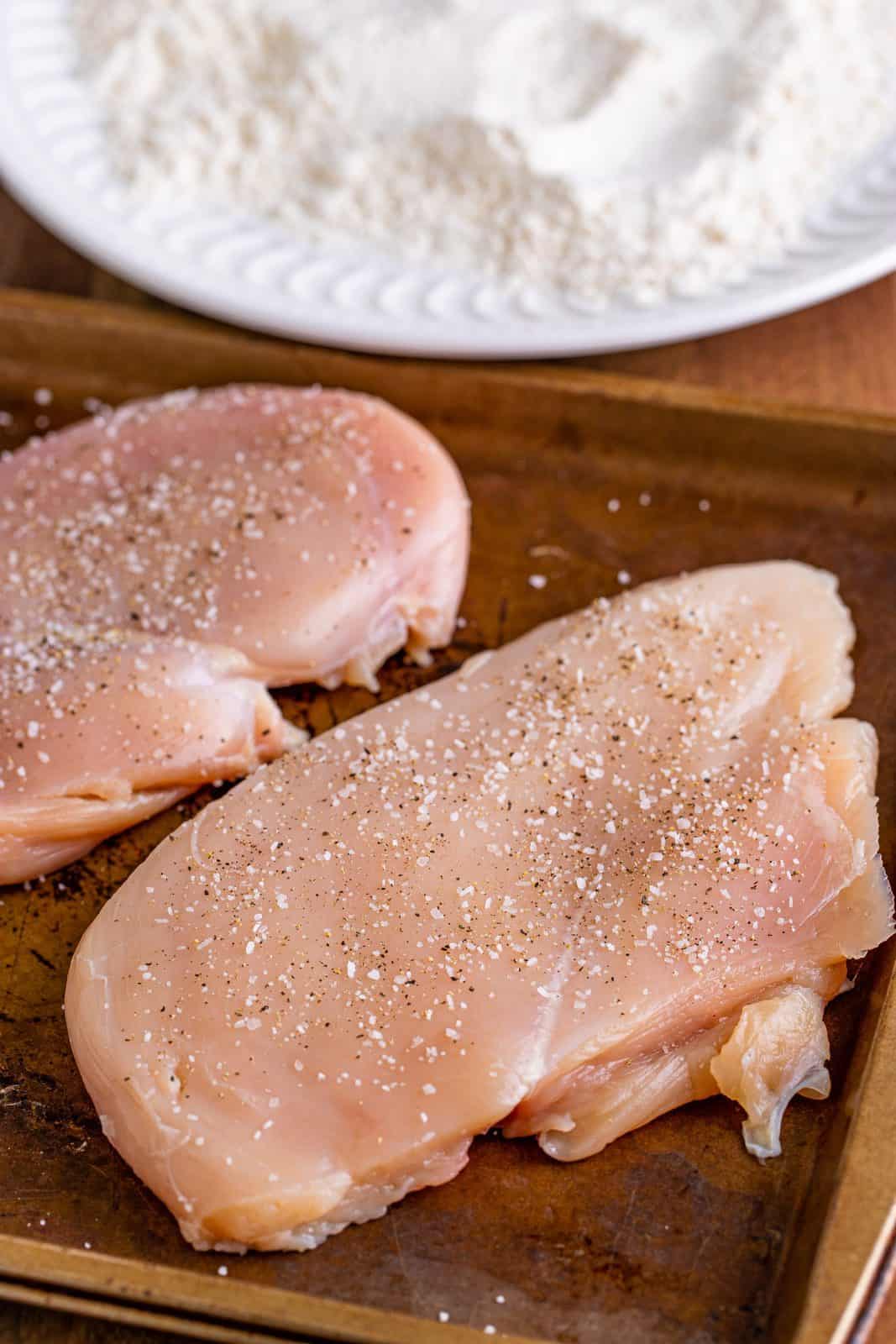 Chicken breasts seasoned with salt and pepper.
