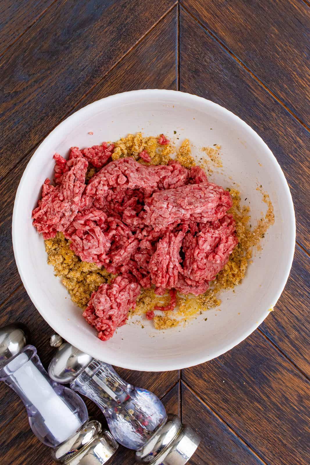 Ground beef added to mixture in bowl.