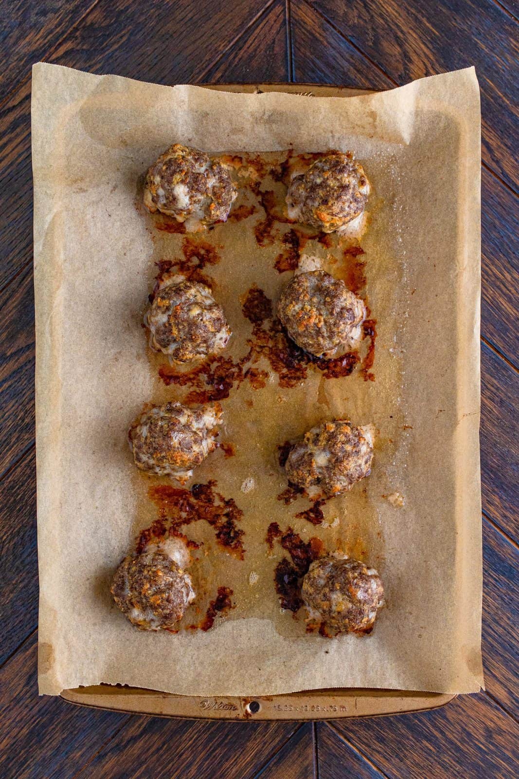 Finished meatballs out of oven on parchment lined pan.