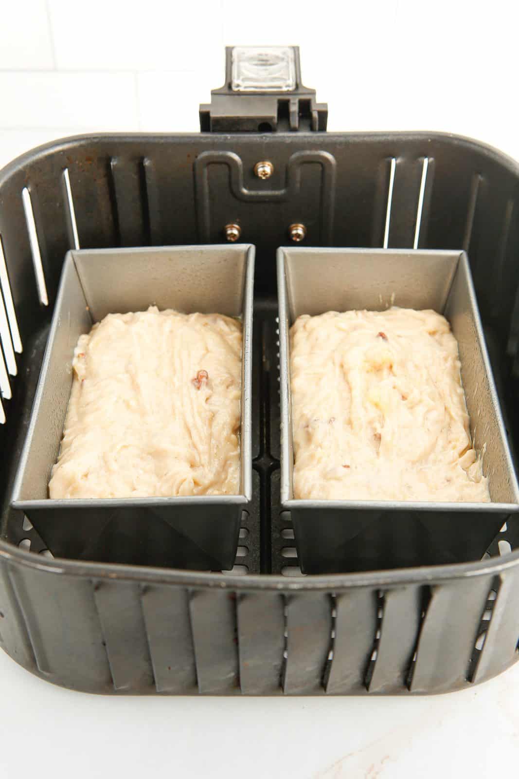 Batter added to mini loaf pans in air fryer basket.