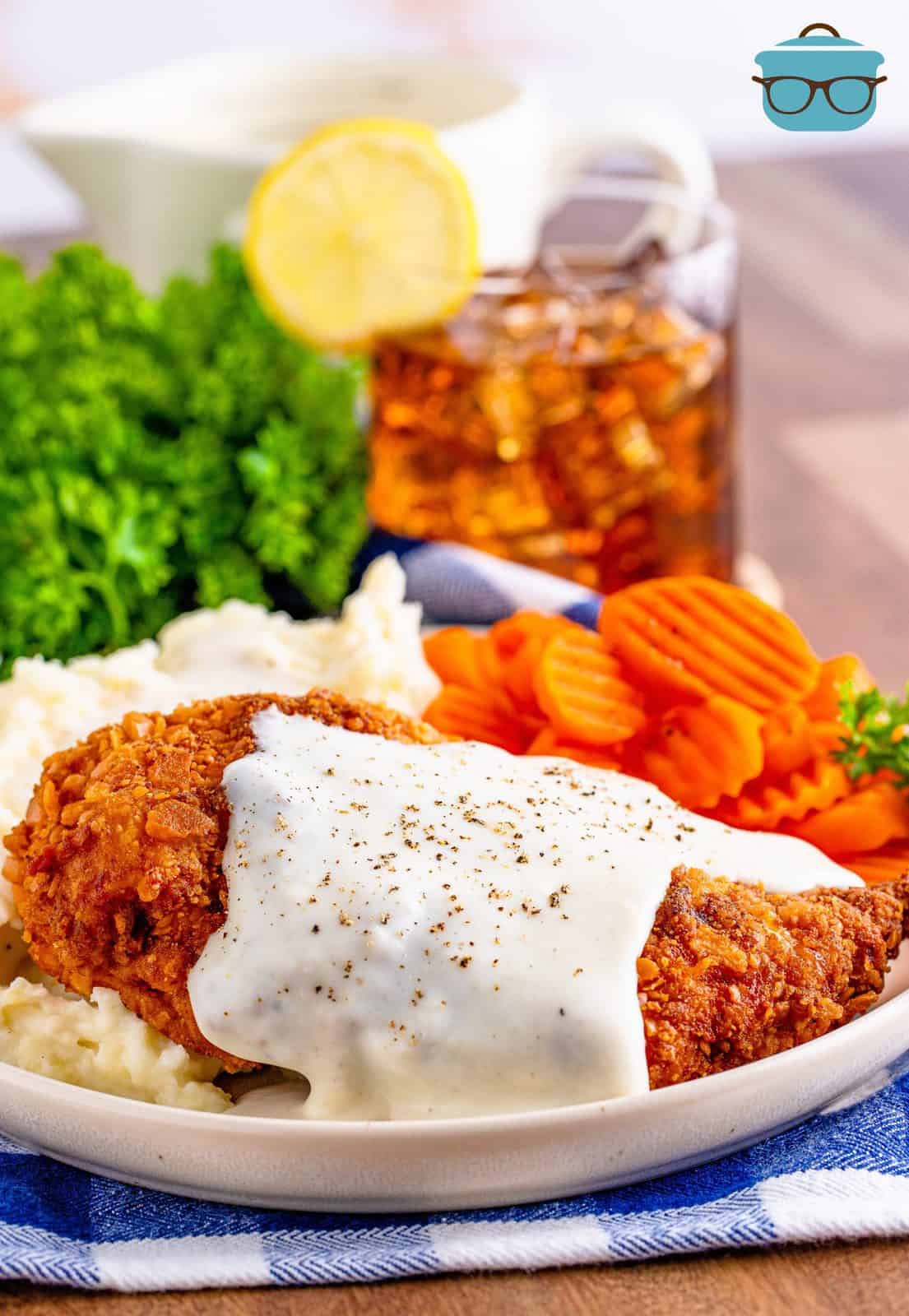 Chicken Fried Chicken on plate with mashed potatoes and carrots.