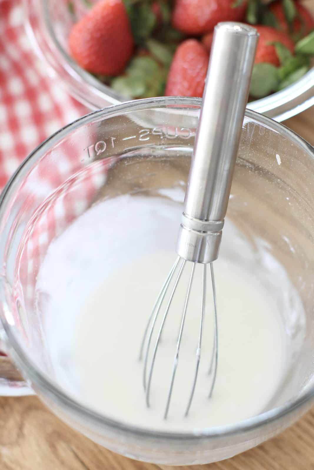 powdered sugar and milk whisked together in a small measuring bowl.