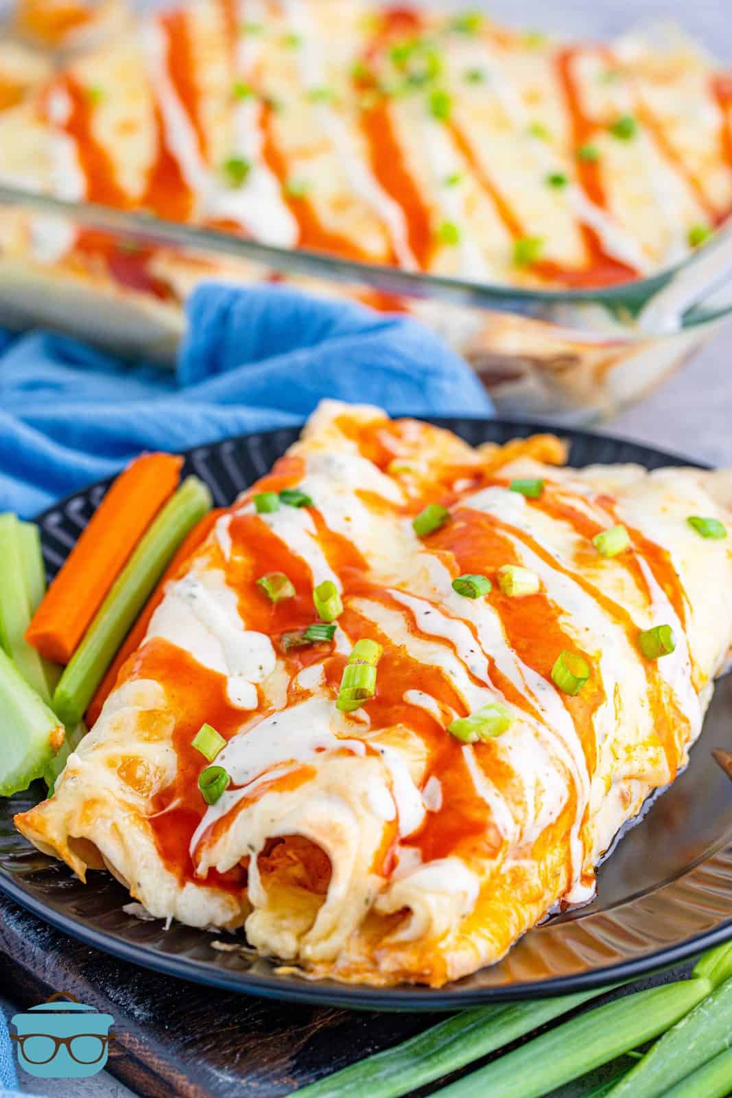 Buffalo Chicken Enchiladas on plate topped with buffalo sauce and ranch.