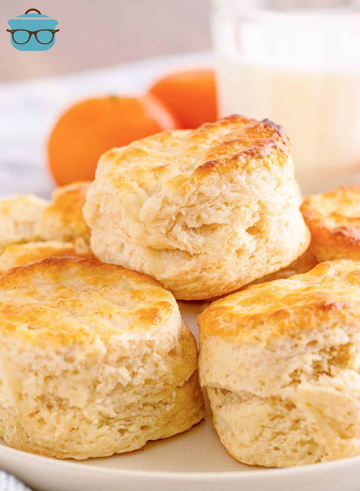 Stacked Southern Buttermilk Biscuits on top of one another on white plate.