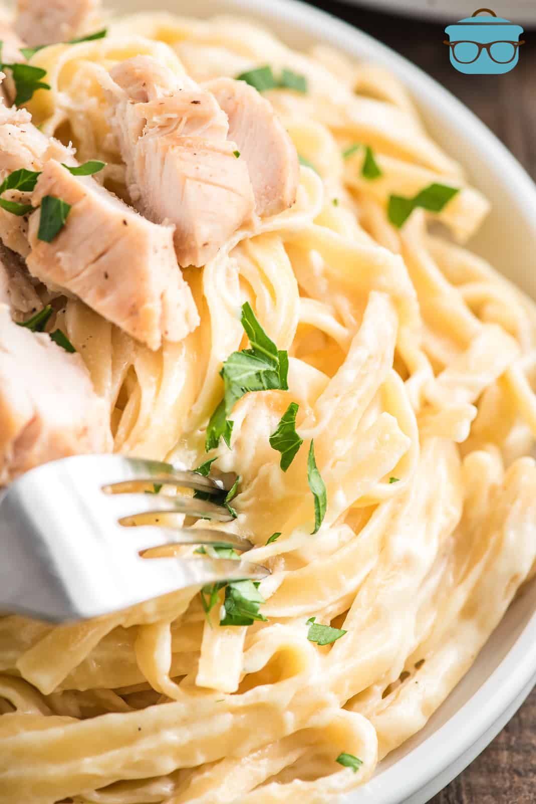 Close up of Copycat Olive Garden Chicken Alfredo in bowl with fork.