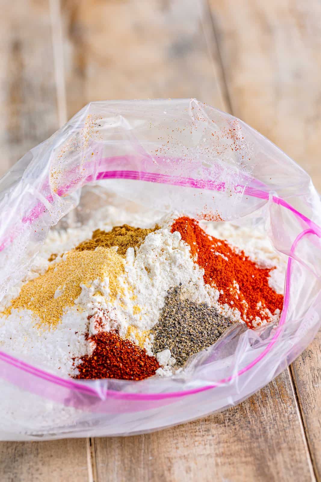 Flour, salt, chili powder, paprika, cumin and pepper added to a ziplock bag.