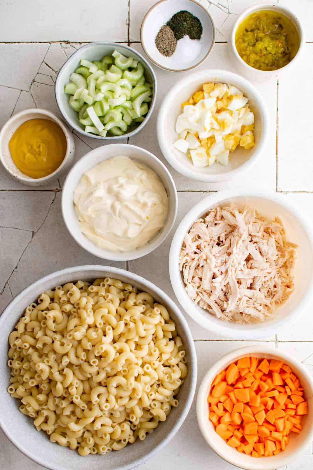 Ingredients needed: mayonnaise, yellow mustard, dill pickle relish, dried dill, salt, pepper, celery, hard-boiled eggs, carrots, shredded chicken and macaroni pasta.