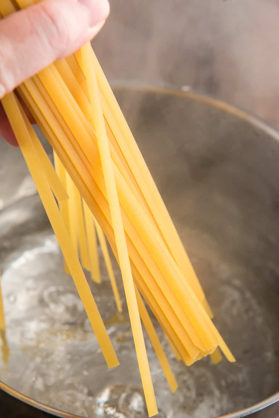 Pasta being placed in water to cook.