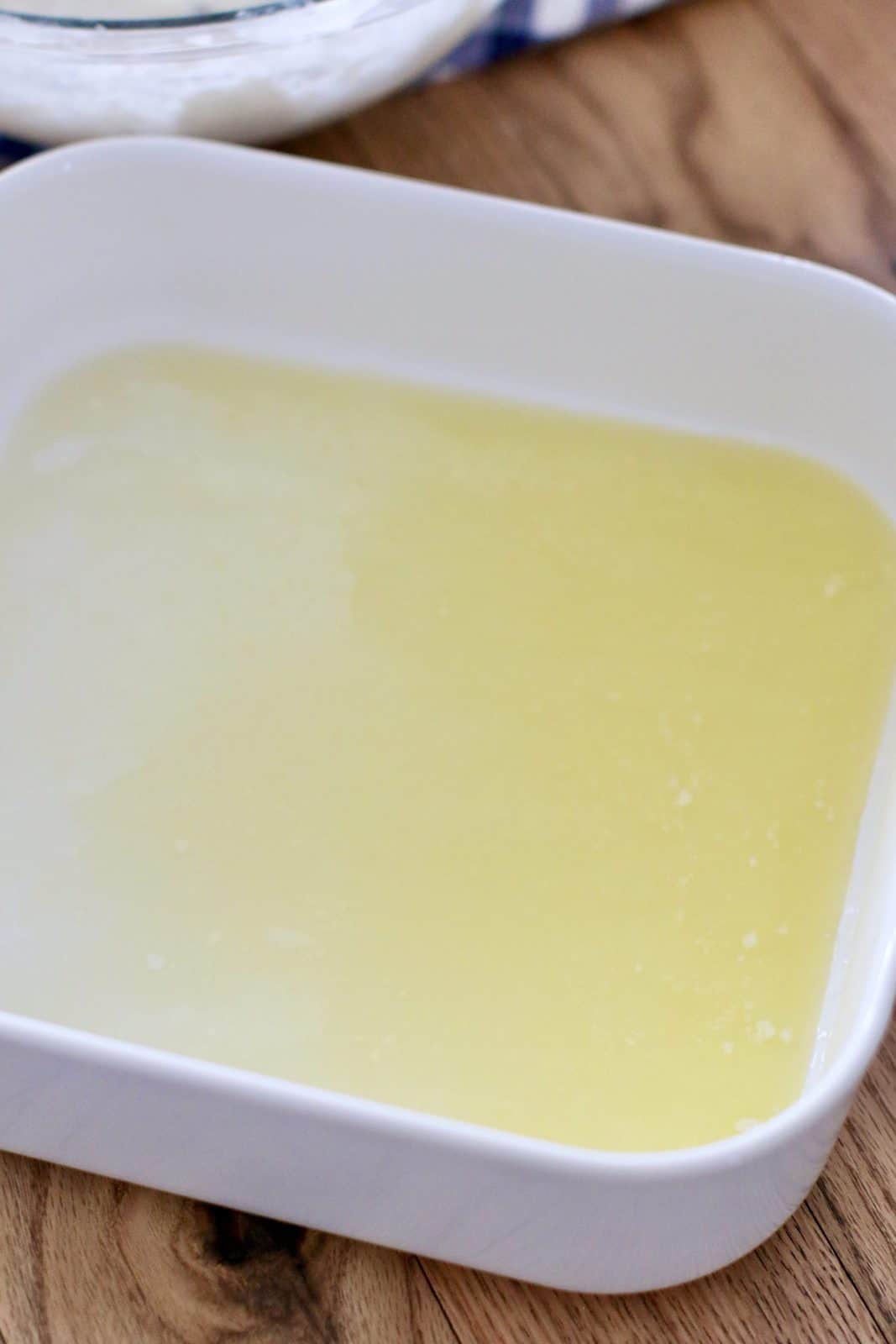 melted butter in a white square baking dish.