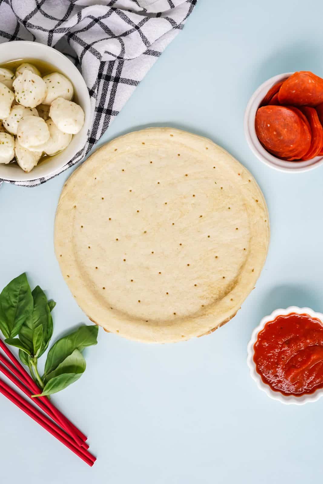 Ingredients needed: pre-made pizza crusts, marinated mozzarella balls, pepperoni, fresh basil leaves and pizza sauce.