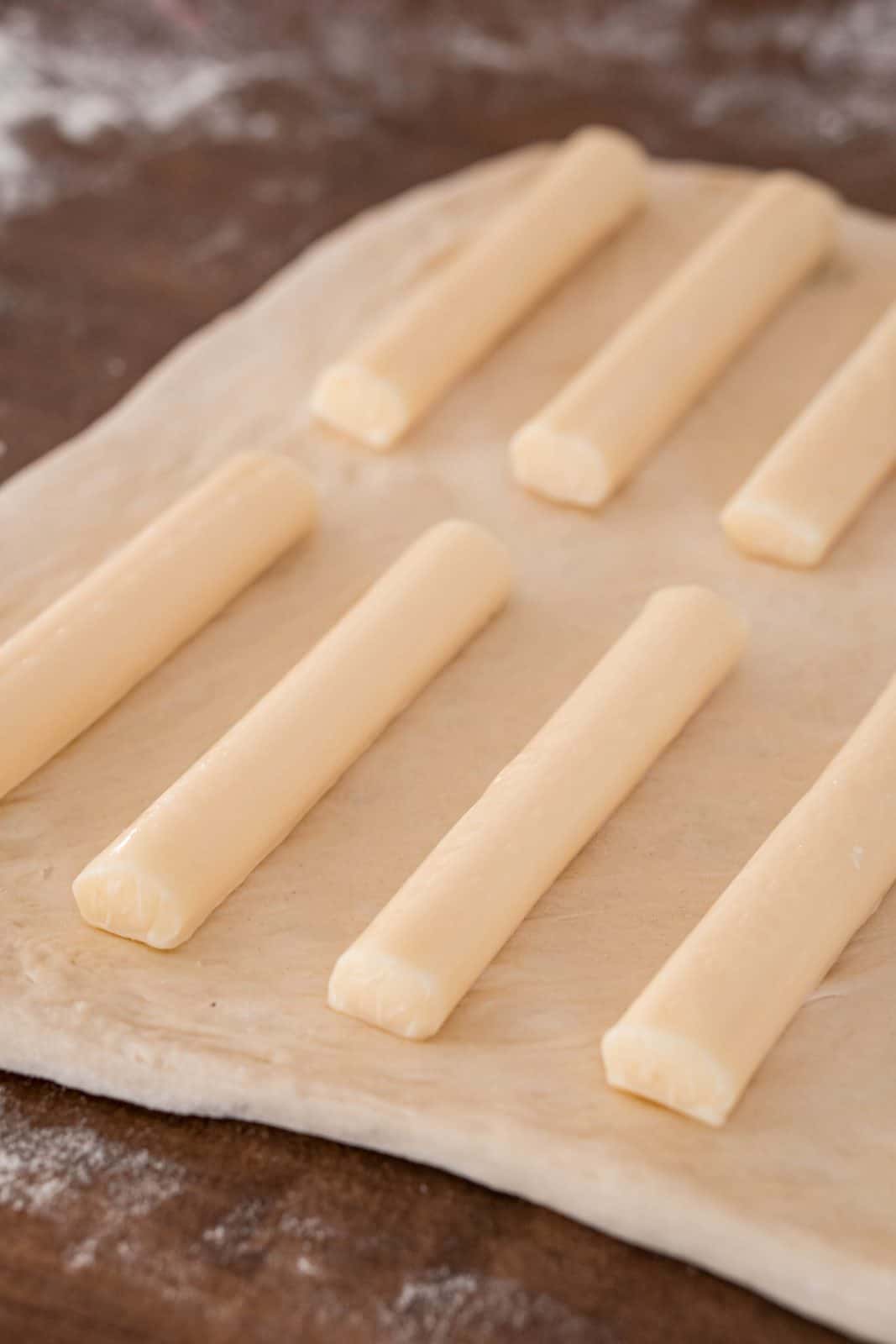 String cheese placed on top of pizza dough.