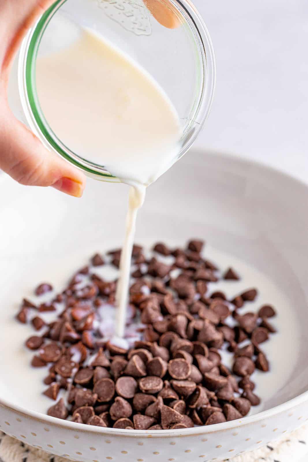 Milk being poured over chocolate chips.
