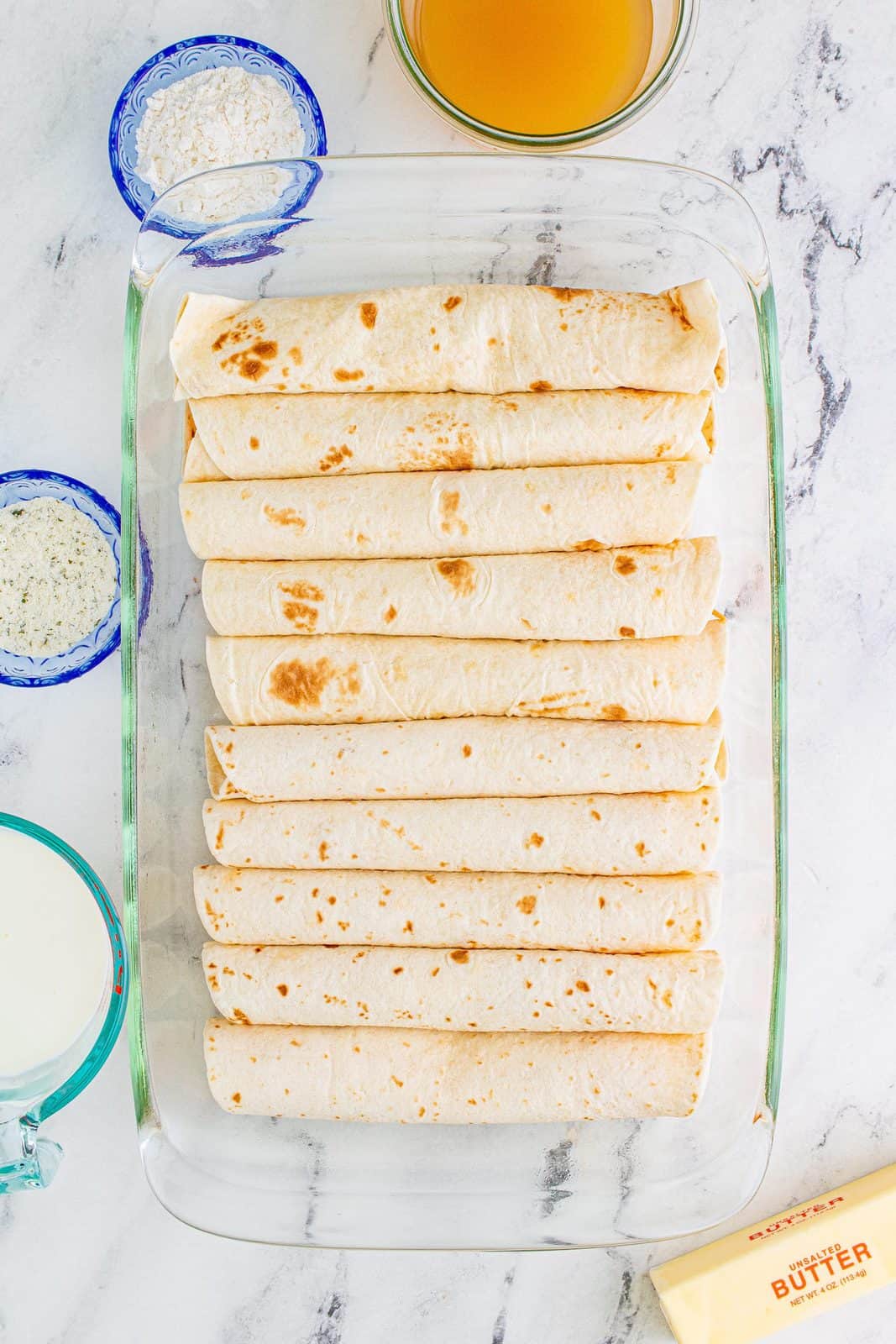 Rolled tortillas placed in prepared pan.