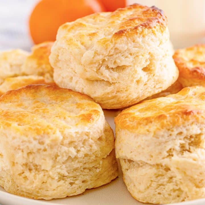 Square image of stacked Southern Buttermilk Biscuits on white plate.