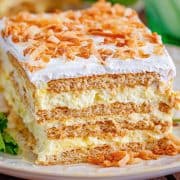 Square image close up showing layers of Coconut Icebox Cake on white plate.