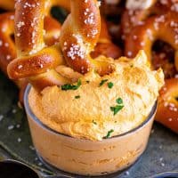 Square image close up showing pretzel in thick Beer Cheese Dip.