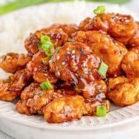 Square image of Easy Sesame Chicken on plate with rice.