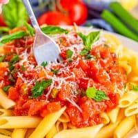 Square image of Easy Tomato Basil Sauce over pasta on plate with fork.