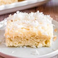Square image of Frosted Coconut Sugar Cookie Bar on white plate.