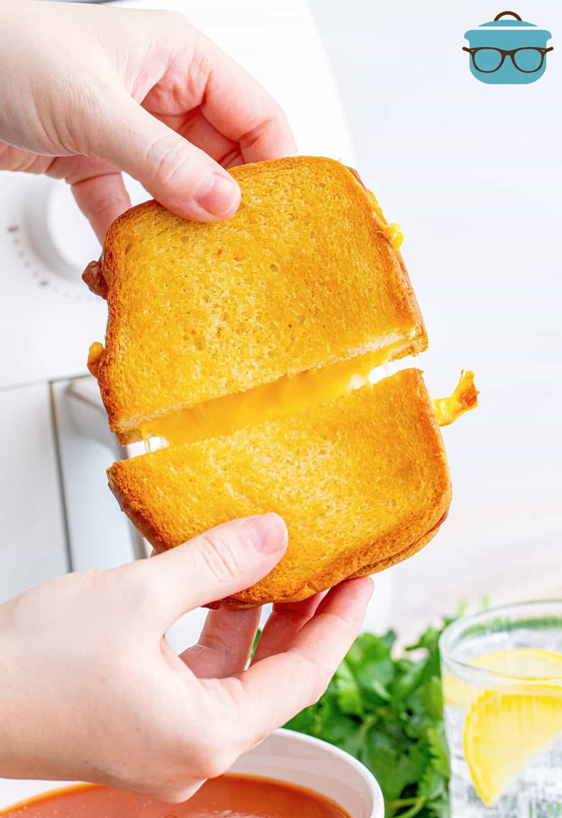 Hands pulling Air Fryer Grilled Cheese apart showing cheese pull.