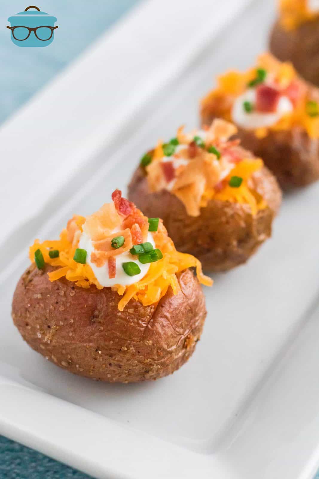 Lined up Air Fryer Baby Baked Potatoes on white platter.