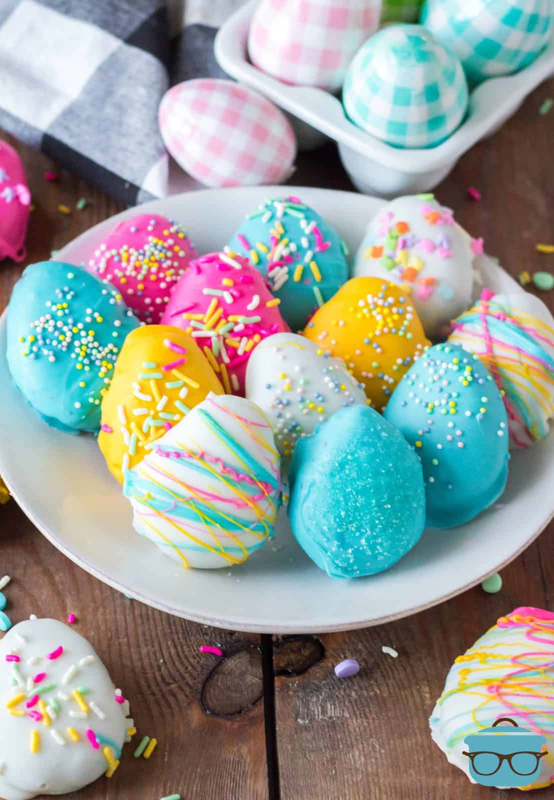 Colored Easter Egg Oreo Truffles on white plate with more truffles surrounding it.