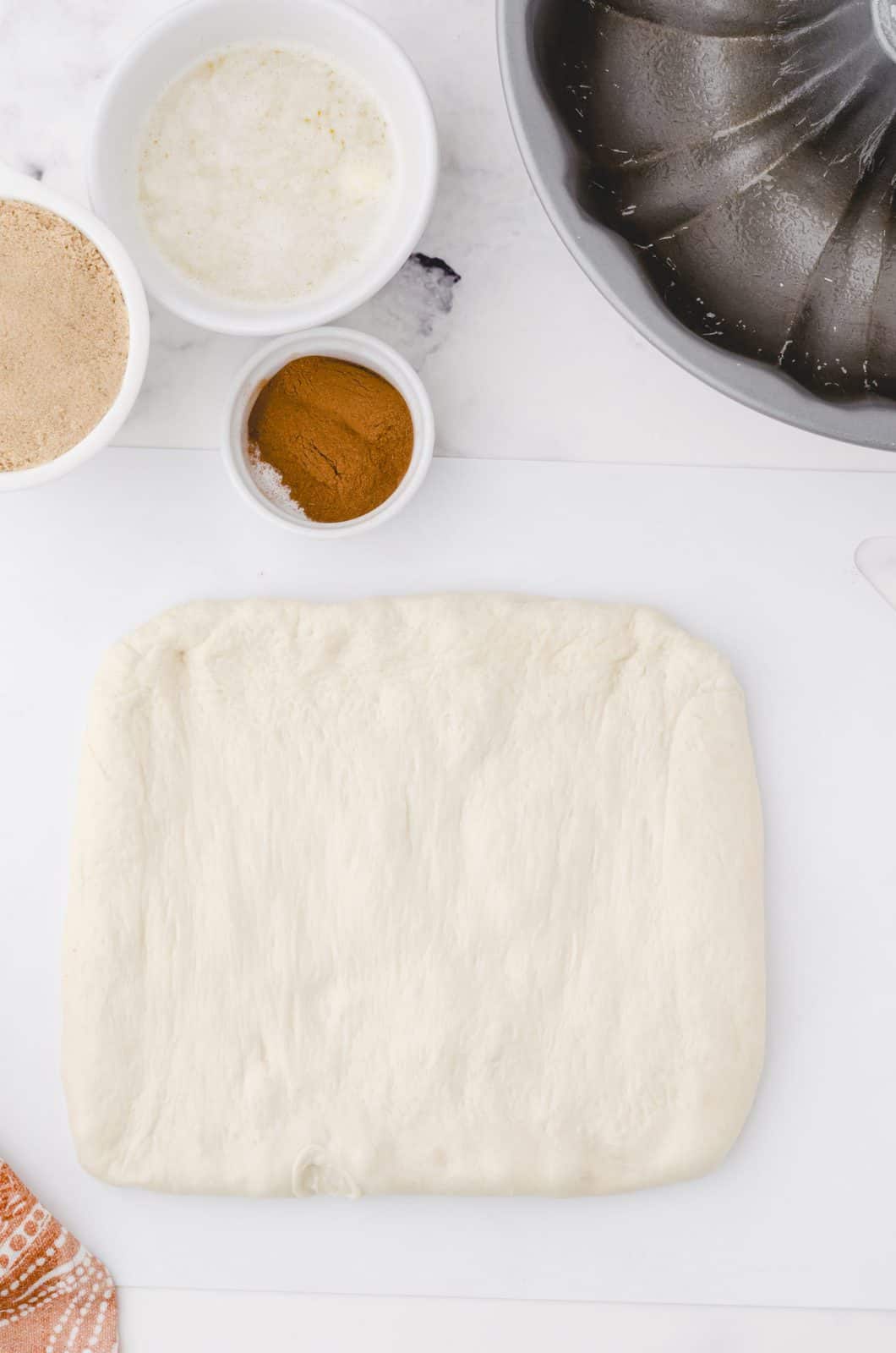 Thawed bread dough patted into a square.